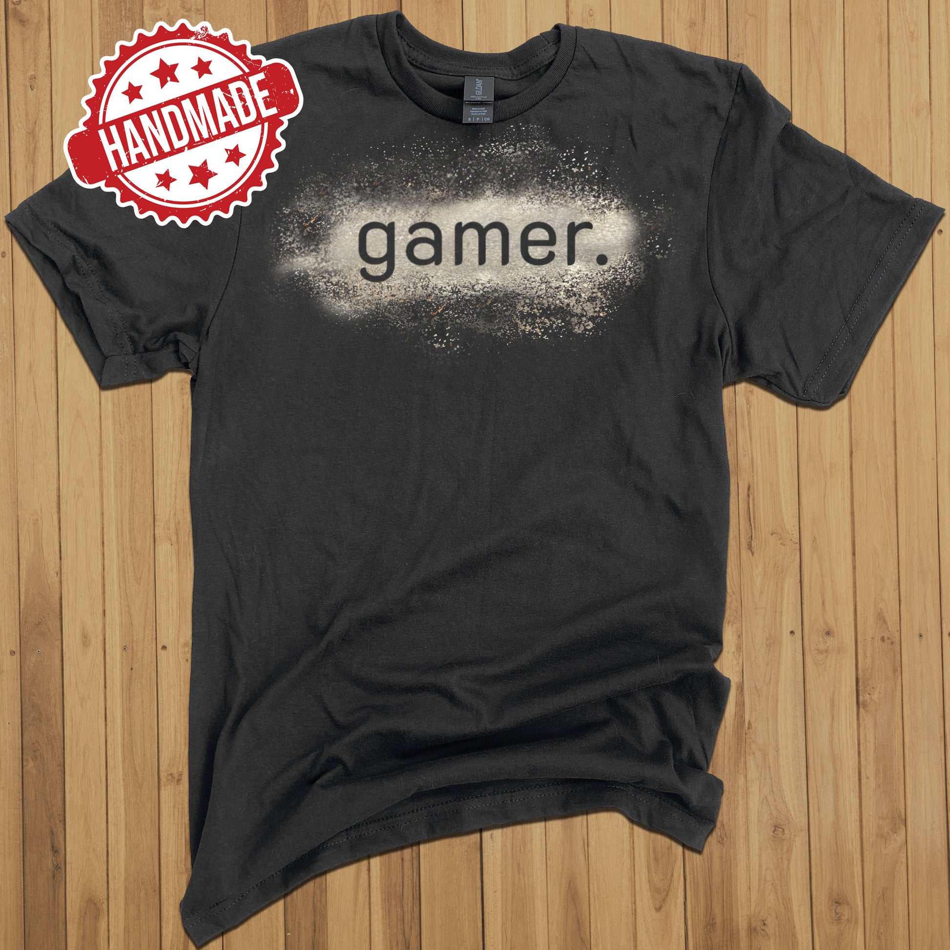 Black tee shirt with a design that says "gamer", which has been created with bleach