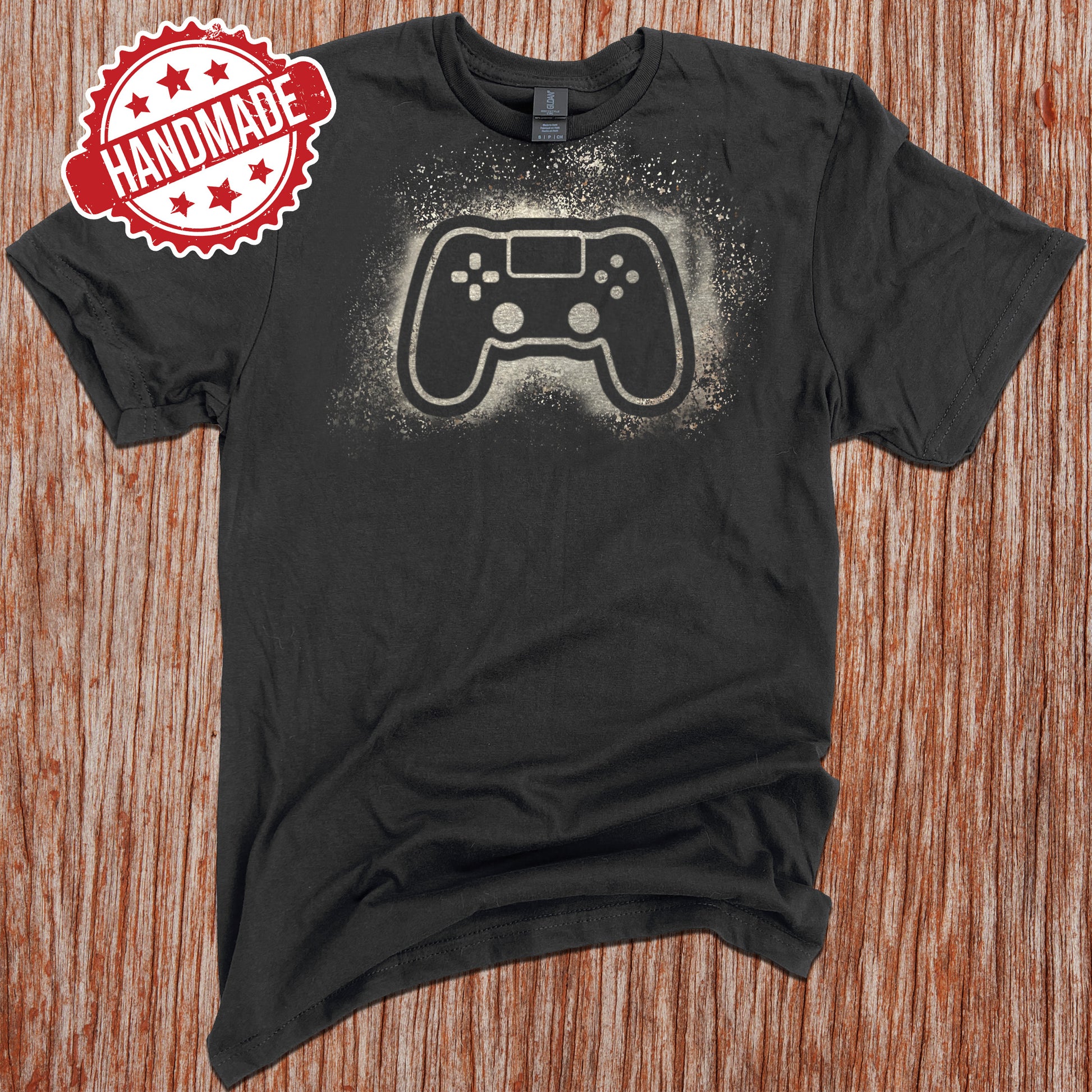 A black shirt with the classic Playstation controller design made with bleach