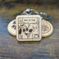 square wooden keychain with an engraved image of the "this is fine" dog in a house on fire 
